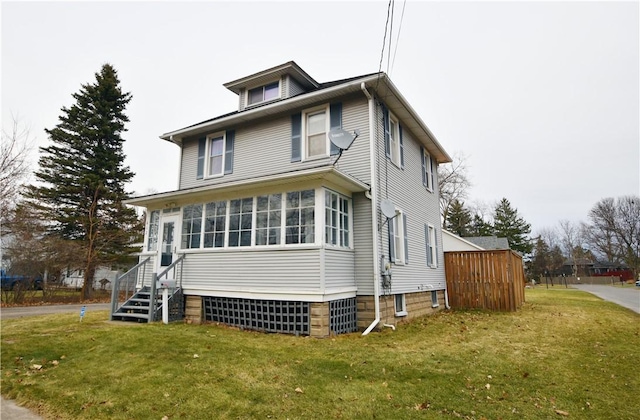 american foursquare style home featuring entry steps and a front lawn