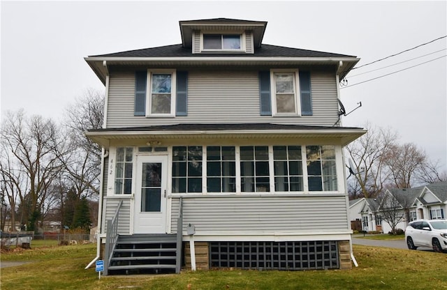 exterior space featuring entry steps, a front lawn, and a sunroom