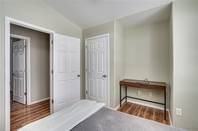 bedroom featuring vaulted ceiling, baseboards, and wood finished floors