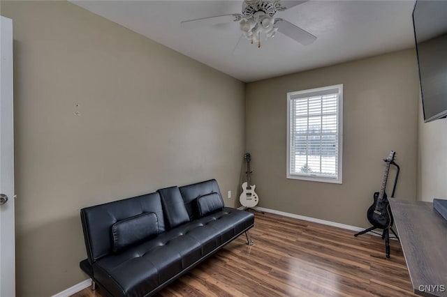 living area featuring ceiling fan, baseboards, and wood finished floors