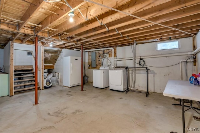 below grade area featuring electric panel, washer and dryer, and freestanding refrigerator