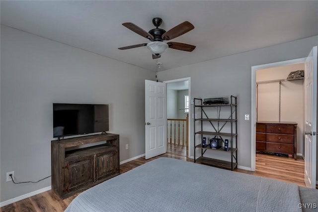 bedroom featuring a ceiling fan, baseboards, and wood finished floors