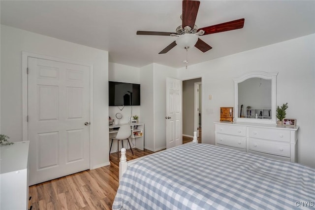 bedroom with light wood-style flooring, built in study area, and ceiling fan