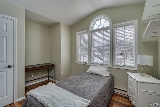 bedroom featuring vaulted ceiling, baseboard heating, and wood finished floors