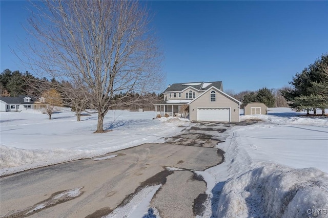 view of front facade with a garage, an outbuilding, and concrete driveway