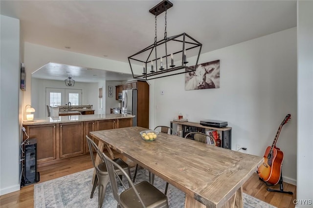 dining area featuring arched walkways, light wood-type flooring, and baseboards