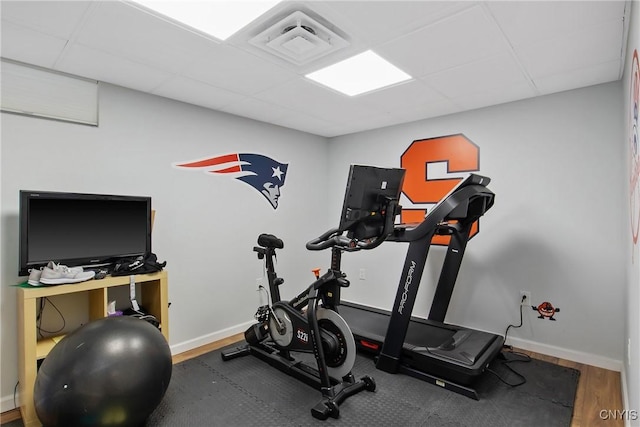 workout room with wood finished floors, baseboards, visible vents, and a drop ceiling