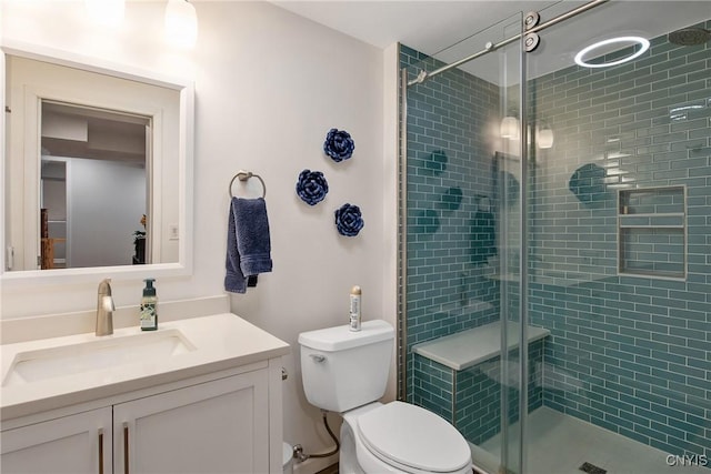 bathroom with vanity, a shower stall, and toilet