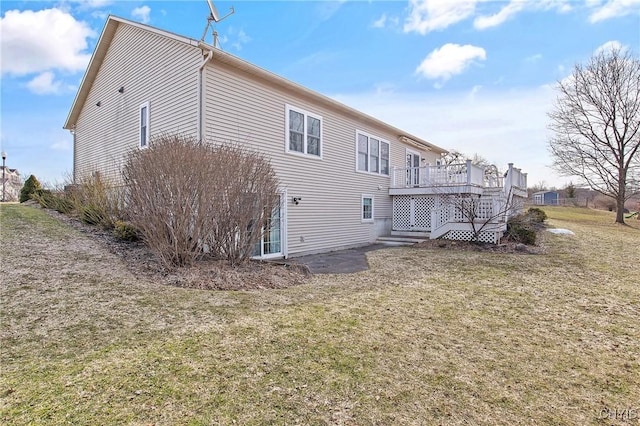 back of property featuring a yard and a wooden deck