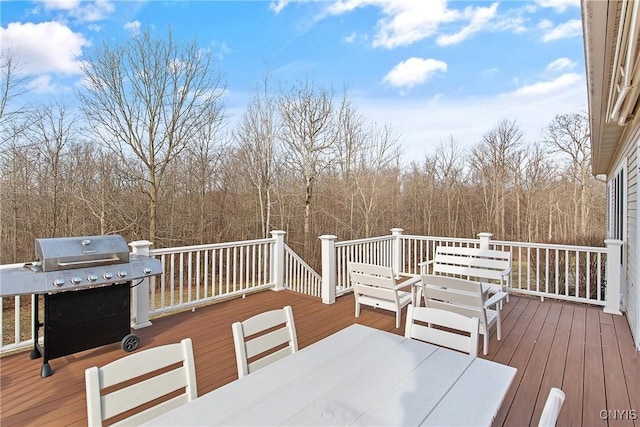 wooden terrace featuring grilling area and outdoor dining area