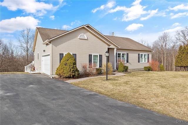 ranch-style home featuring a front yard, an attached garage, and driveway