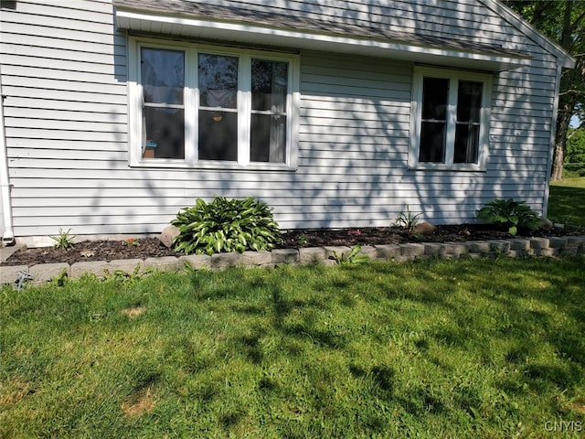 view of property exterior with a yard and roof with shingles