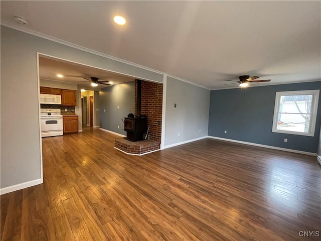 unfurnished living room with crown molding, a wood stove, and dark wood-type flooring