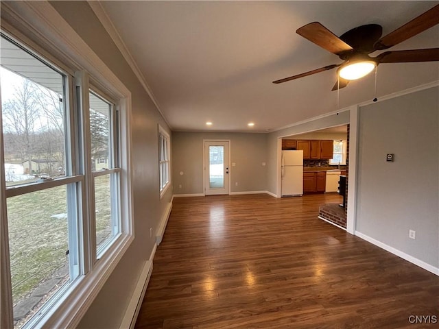 unfurnished living room with dark wood finished floors, recessed lighting, baseboards, and ornamental molding