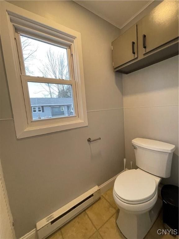 bathroom with baseboards, baseboard heating, tile patterned flooring, and toilet