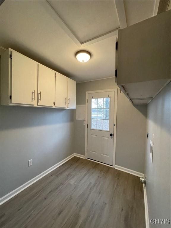 interior space with baseboards, cabinet space, and dark wood-style flooring