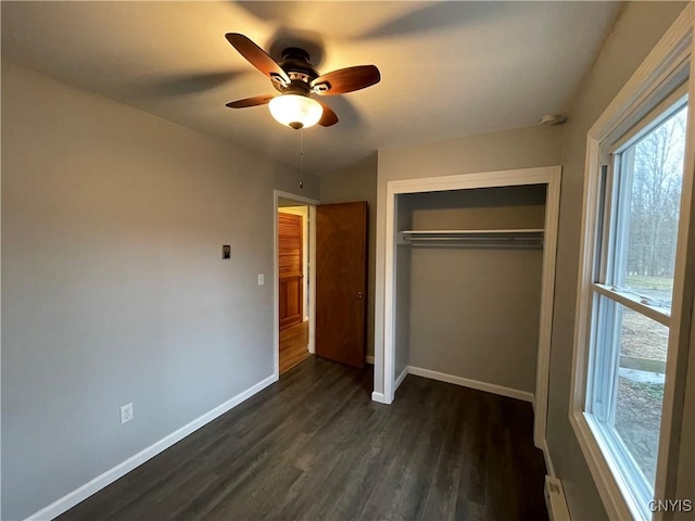 unfurnished bedroom featuring a closet, baseboards, a ceiling fan, and dark wood-style flooring