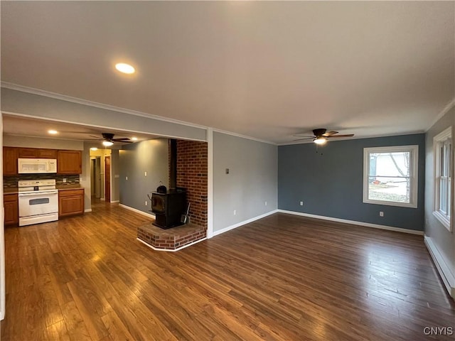 unfurnished living room with dark wood finished floors, a wood stove, and baseboards