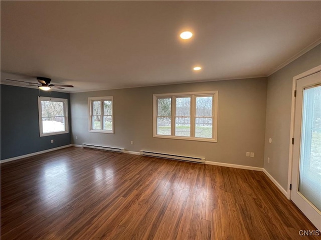 spare room with baseboards, baseboard heating, dark wood-style flooring, and crown molding