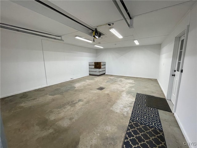 garage with a garage door opener and baseboards