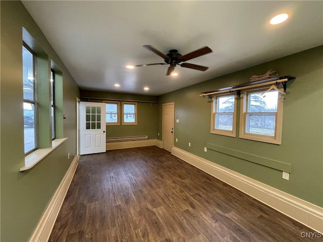 empty room featuring dark wood finished floors, plenty of natural light, and baseboards