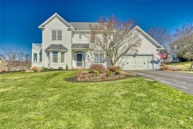 view of front facade featuring aphalt driveway, a garage, and a front yard