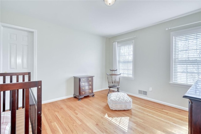 bedroom featuring multiple windows, visible vents, light wood-type flooring, and baseboards