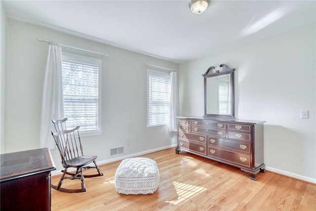 living area featuring visible vents, plenty of natural light, and light wood-style flooring