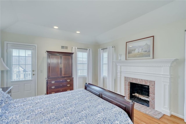 bedroom featuring visible vents, recessed lighting, a fireplace, and light wood-type flooring