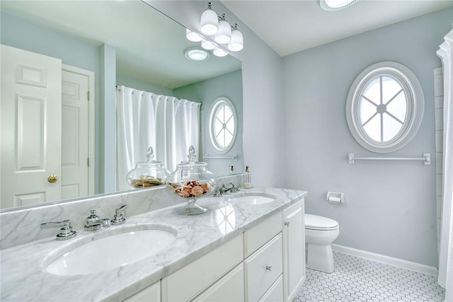 bathroom featuring plenty of natural light, baseboards, and a sink