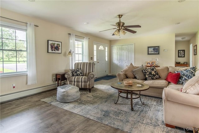 living room featuring baseboard heating, ceiling fan, and wood finished floors