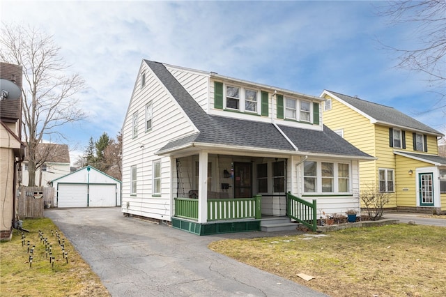 view of front of home with an outdoor structure, a detached garage, a front lawn, and roof with shingles