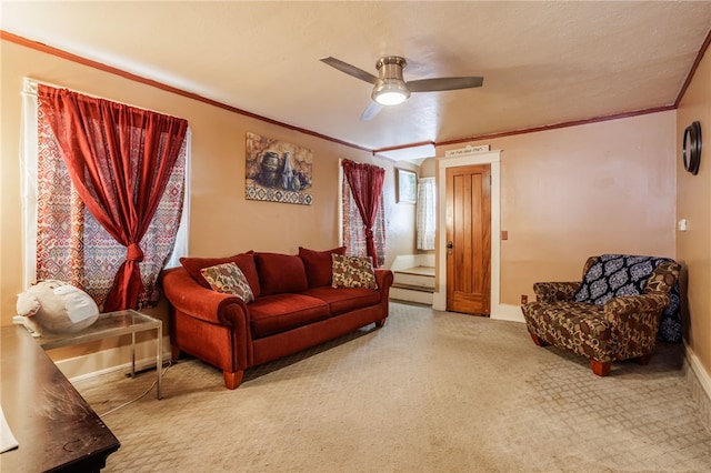 carpeted living area with baseboards, ceiling fan, and ornamental molding