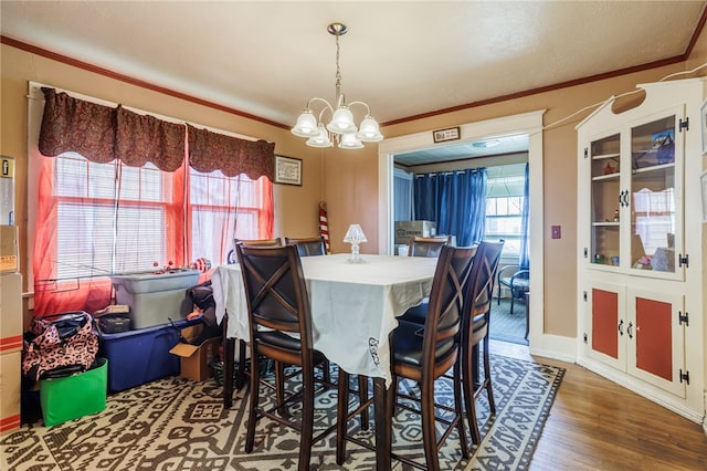 dining room featuring an inviting chandelier, wood finished floors, and ornamental molding