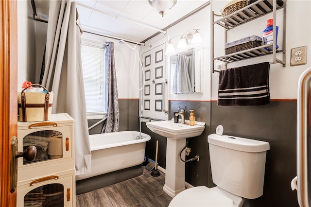 bathroom featuring curtained shower, toilet, wood finished floors, and a washtub