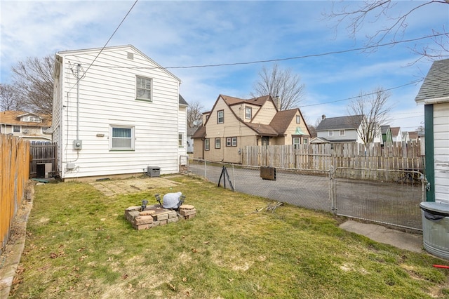 exterior space featuring a residential view, a lawn, central air condition unit, and a fenced backyard