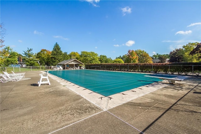 pool with a patio and fence