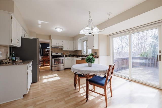 dining area featuring a notable chandelier and light wood finished floors