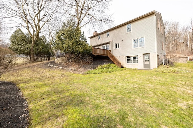 back of property featuring a deck, central AC unit, stairway, and a lawn