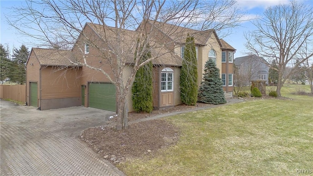 view of front of property featuring decorative driveway, a garage, roof with shingles, and a front yard