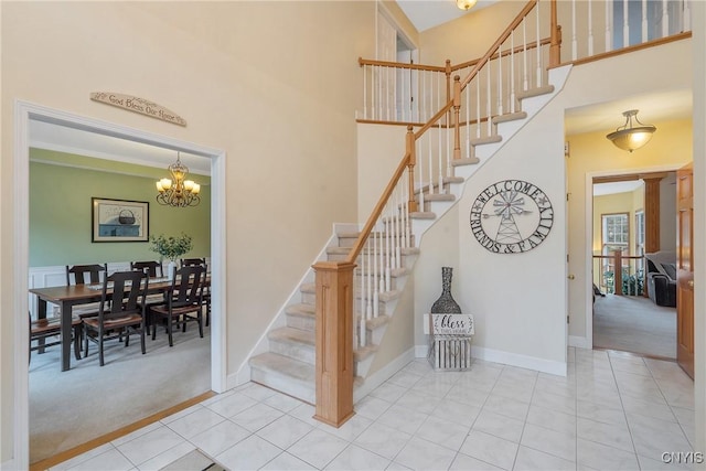 stairway featuring tile patterned floors, baseboards, carpet floors, and a towering ceiling