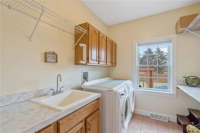 laundry room with baseboards, visible vents, cabinet space, a sink, and washer and dryer