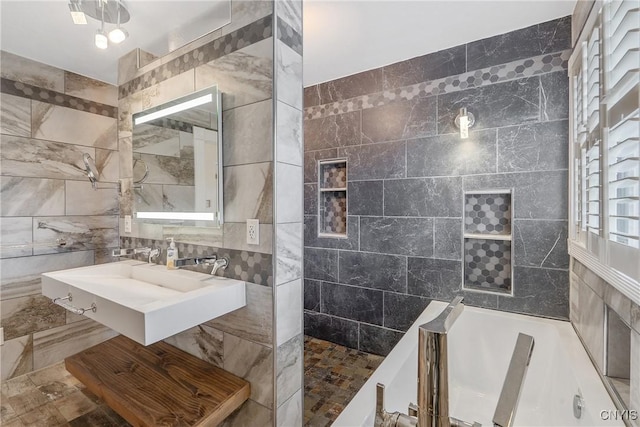 full bath featuring a sink, tile walls, and walk in shower