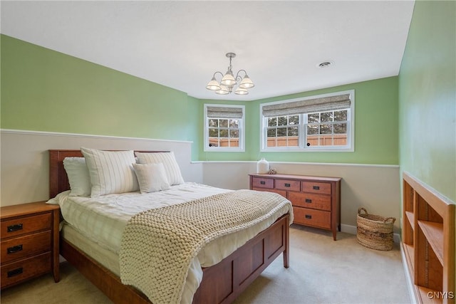 bedroom with light colored carpet and a chandelier