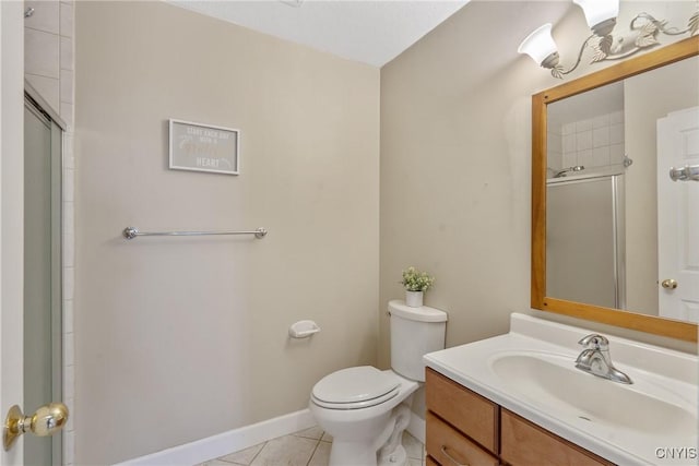 bathroom featuring tile patterned flooring, baseboards, toilet, a shower with shower door, and vanity