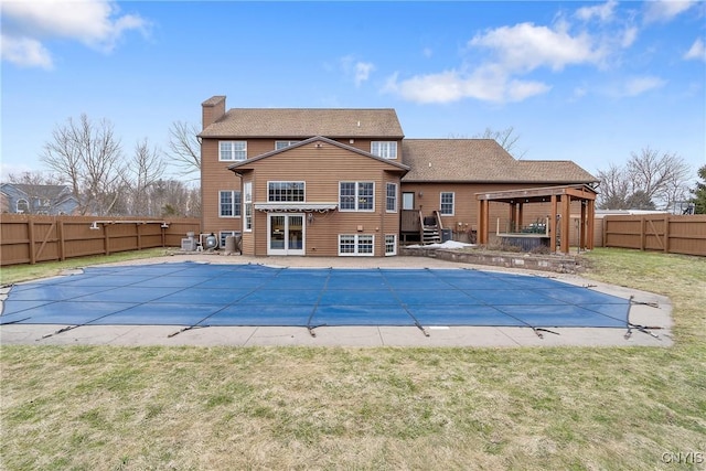 view of swimming pool with a yard, a fenced in pool, and a fenced backyard