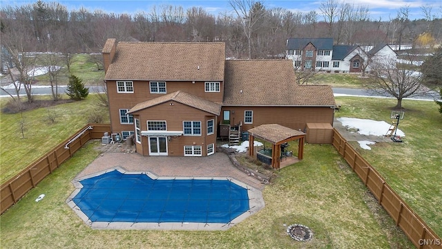 back of property with a fenced in pool, a chimney, a yard, a fenced backyard, and a patio