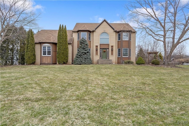 view of front facade with a front yard and brick siding