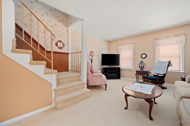 living room with baseboards, carpet, stairs, and wallpapered walls