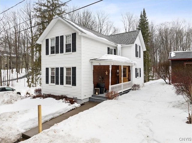 view of front of property featuring covered porch and a shingled roof